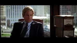 man in suit sitting by window with cityscape view — Batman: The Dark Knight