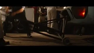 man pushing tire in garage — Ford v Ferrari